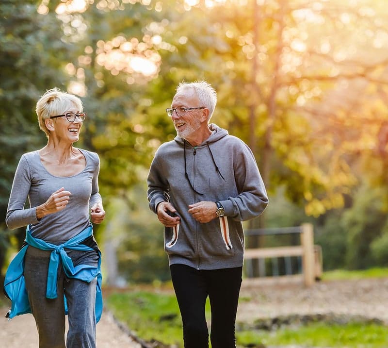 Couple walking outdoors after man had spine surgery