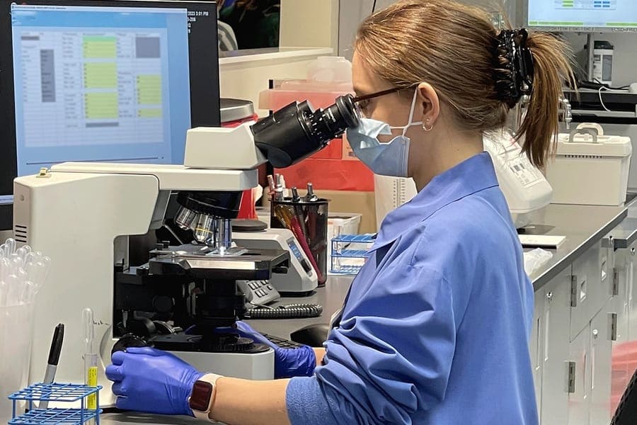 A woman looks into laboratory equipment