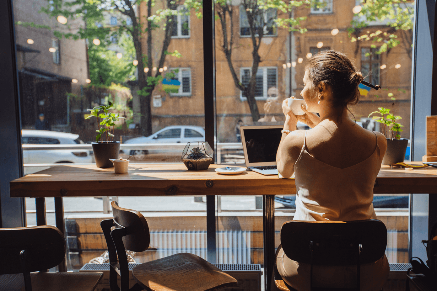 woman relaxing drinking tea while sitting near the window in a cafe