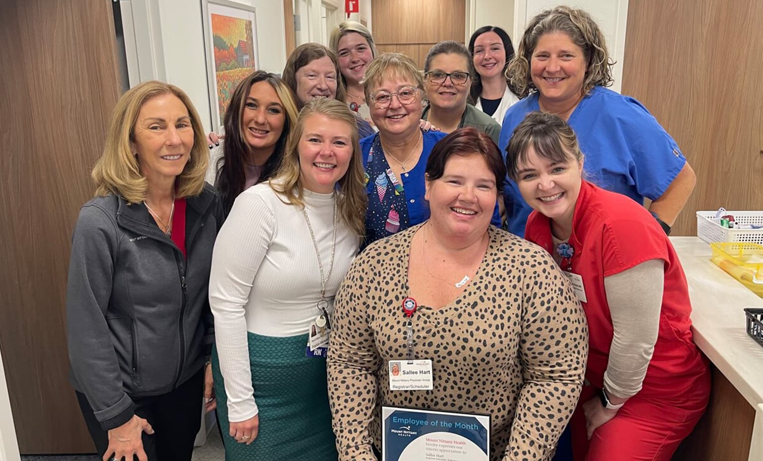 A group of people gather for a photo with Sallee Hart, employee of the month winner
